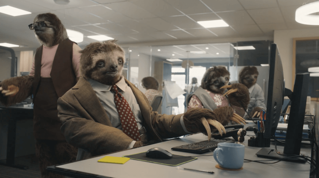 Several sloths dressed in office attire vociferously collaborate and interact in a modern office environment.